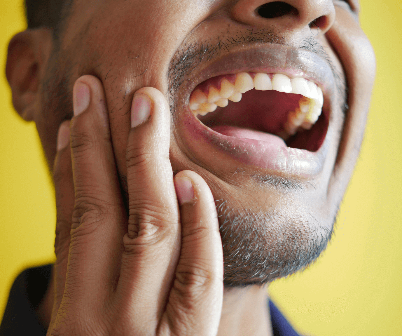 Man holding his jaw in pain with a dental emergency