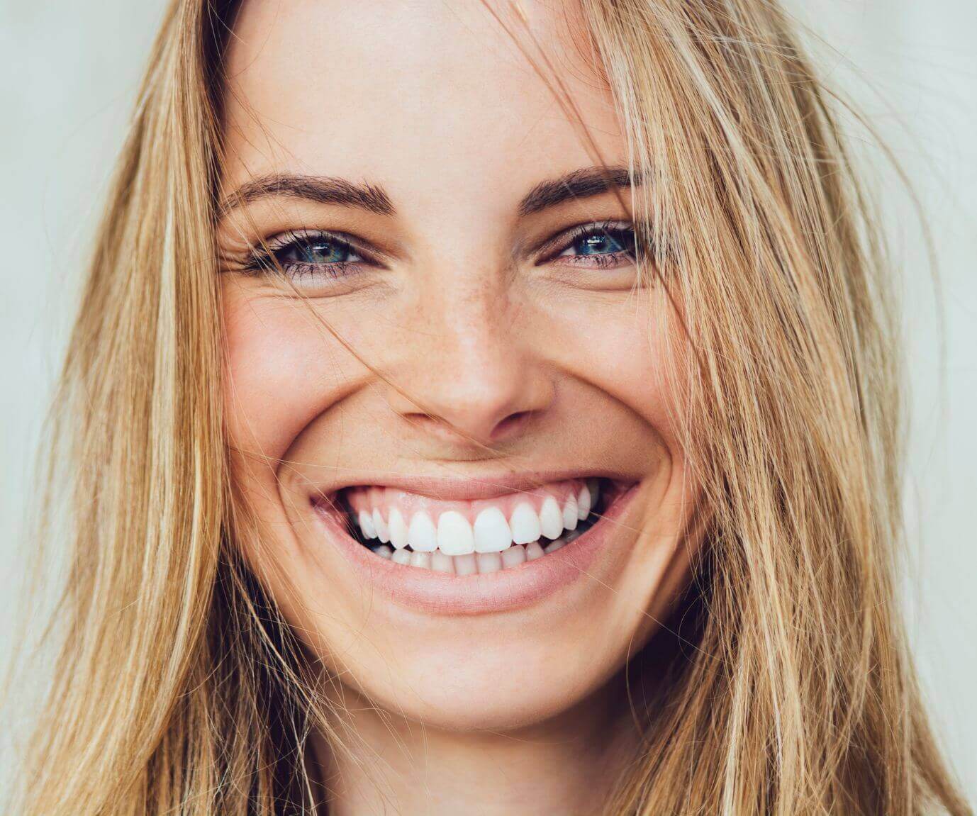 Woman smiling with white teeth after teeth whitening at The Care Dental Practice