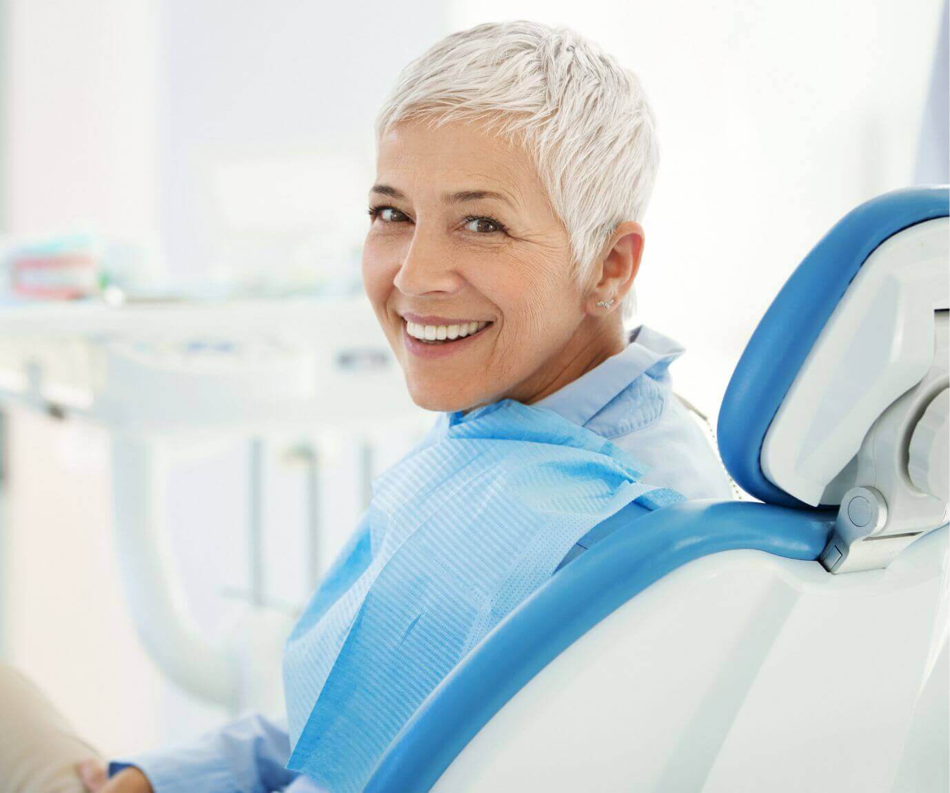 woman smiling in treatment chair after gum disease treatment